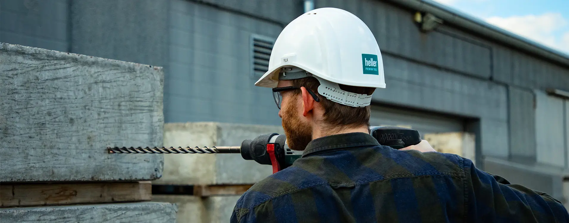 Mann bohrt mit einem SDS-Bohrer in eine Wand