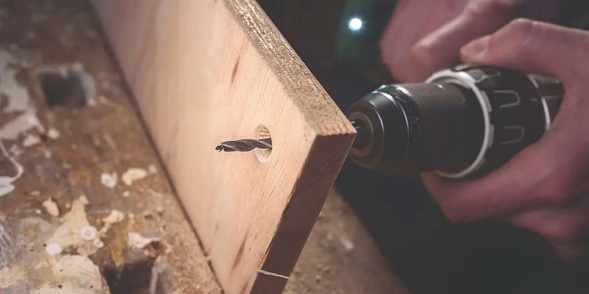 Ein Holzbohrer bohrt durch ein Brett